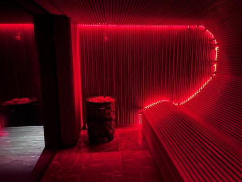 a red lighted room with a trashcan in the corner at Harmony Resort & Spa in Padumble