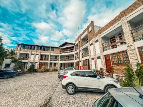 a white car parked in front of a building at Falésia Praia Hotel in Canoa Quebrada