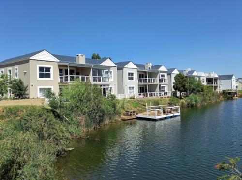 a boat on a river next to some houses at BKM Lake View Retreat at Leisure Bay Estate in Pretoria