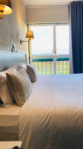 a white bed with pillows and a window at Estremoz Hotel in Estremoz