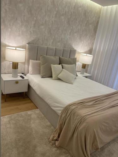ein Schlafzimmer mit einem großen weißen Bett und zwei Lampen in der Unterkunft LUX BeACH in Praia da Barra