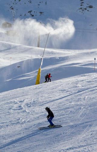 two people are skiing down a snow covered slope at Apartaments Bonet in Pal
