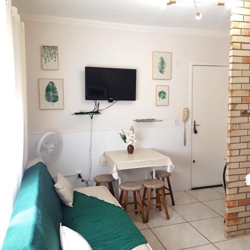 a living room with a couch and a table at Excelente apto a 1 quadra do mar in Capão da Canoa