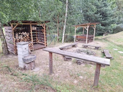 a wooden bench in a field with a wooden shelter at Penzion Na Pohoři in Olešnice