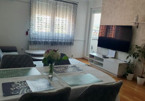 a living room with a table with flowers on it at Istocno Sarajevo, Lukavica, Great View Apartment in Donje Mladice
