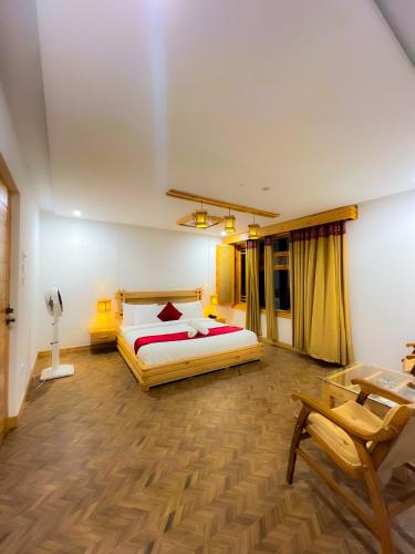 a bedroom with a bed and a table and a chair at Kesar Palace Hotel & Restaurant, Skardu in Skardu