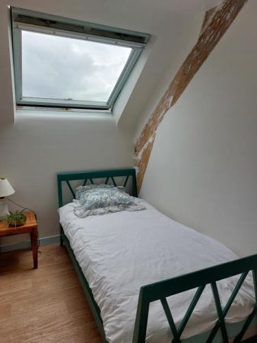 a bedroom with a bed with a large window at Maison de village au Linkin in Perros-Guirec