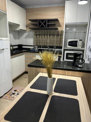 a kitchen with a table with a plant in a vase at Apartamento em Guarapuava in Guarapuava