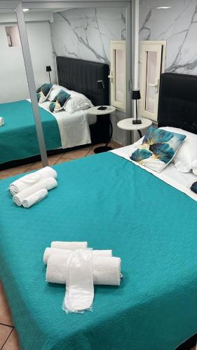 a room with two beds with towels on a table at Sciusciu House in Naples