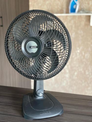 a black fan sitting on top of a table at Apartamento em Guarapuava in Guarapuava