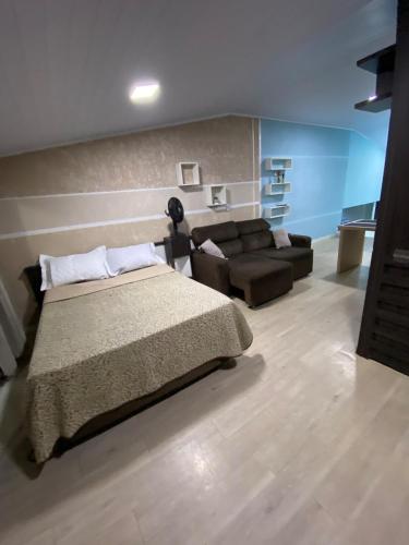 a bedroom with a bed and a couch at Apartamento em Guarapuava in Guarapuava