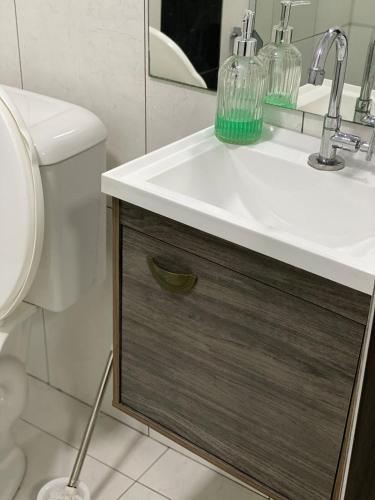 a bathroom with a sink and a toilet at Apartamento em Guarapuava in Guarapuava