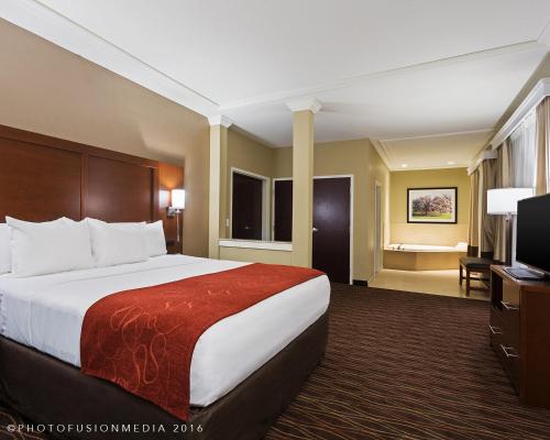 a hotel room with a bed and a flat screen tv at Comfort Suites DuBois Country Club in DuBois