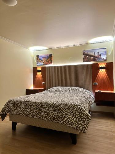 a bedroom with a bed with two lights on it at Departamento Calama in Calama