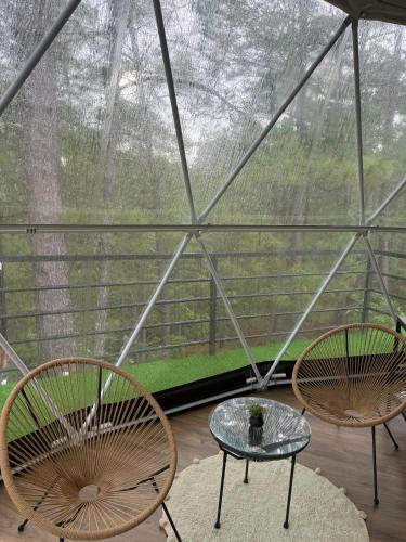 two chairs and a table in front of a glass dome at ThauRana Glamping in Santa Lucía