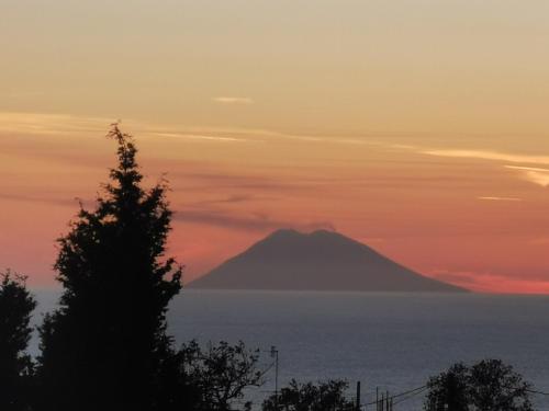 Una montaña en el océano al atardecer en Villa Paradise, en Capo Vaticano