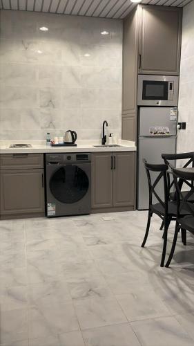 a kitchen with a stove and a sink and a dishwasher at dana hotel apartments in Taif