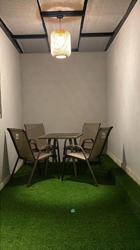 a table and chairs in a room with green carpet at dana hotel apartments in Taif