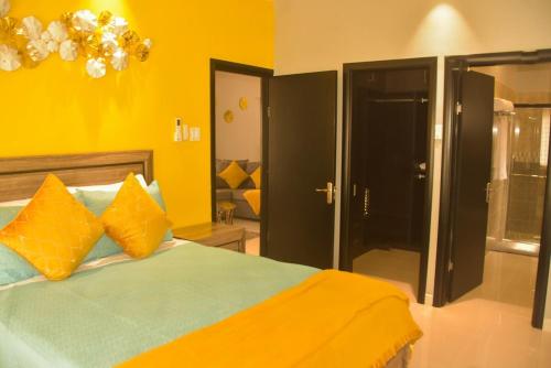 a bedroom with a bed with orange and blue pillows at Oasis Eden Villa in Kupuis