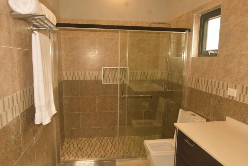 a bathroom with a shower and a toilet at Oasis Eden Villa in Kupuis