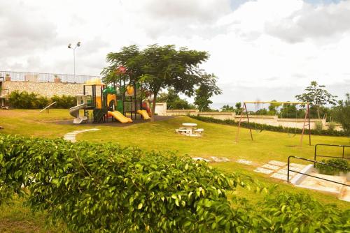 a park with a playground with a swing set at Oasis Eden Villa in Kupuis
