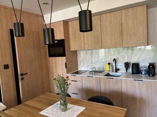 Una cocina con una mesa con un jarrón de flores encima. en Apartament Lena Stare Miasto, en Cracovia