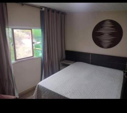 a bedroom with a bed and a window at Casa Lumiar DudaBela in Nova Friburgo