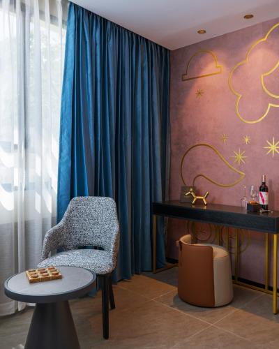 a living room with a chair and a table at Iconic Hotel in Tel Aviv