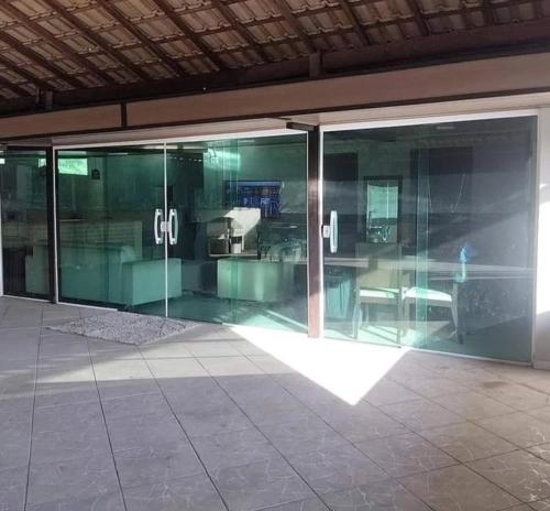 a glass wall in a building with a window at Casa Lumiar DudaBela in Nova Friburgo