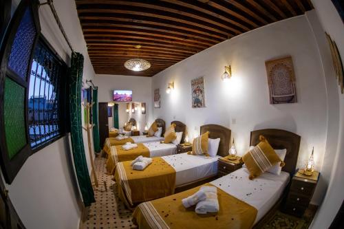 a group of four beds in a room at Riad Shauala Fez in Fès