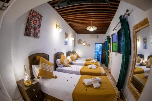 a group of four beds in a room at Riad Shauala Fez in Fès