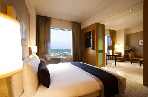 a hotel room with a large bed and a large window at Ambassador Hotel Hsinchu in Hsinchu City