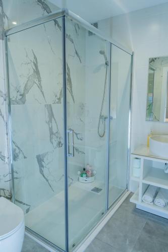 a bathroom with a glass shower with a toilet and a sink at Pousadas CAMINO de FINISTERRE in Mazaricos