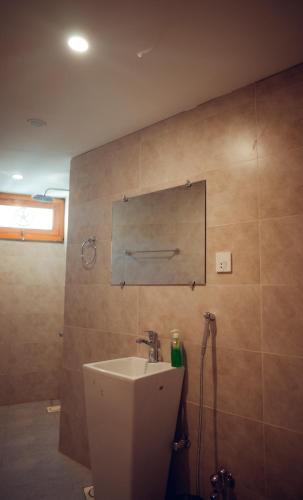a bathroom with a sink and a mirror on the wall at Kesar Palace Hotel & Restaurant, Skardu in Skardu