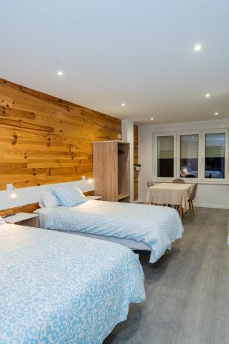 a hotel room with two beds and a table at Pousadas CAMINO de FINISTERRE in Mazaricos