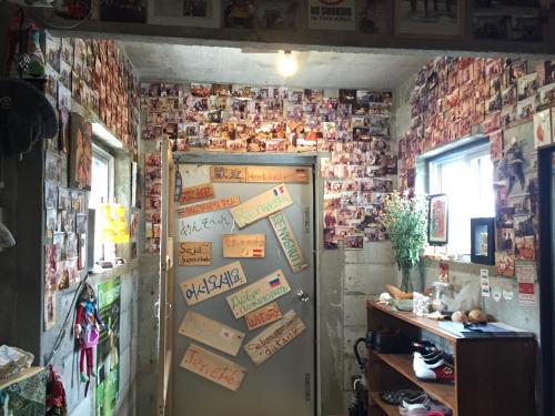 a room with a door with signs on the wall at Guest House Isa in Motobu
