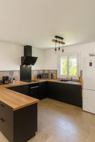 - une cuisine avec des armoires noires et un réfrigérateur blanc dans l'établissement Villa Martigues, à Martigues