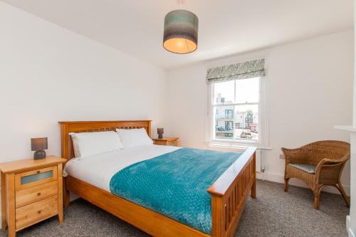 KentにあるTrinity Retreat - Margate Old Townのベッドと椅子と窓のある寝室
