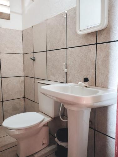 a bathroom with a white sink and a toilet at Aconchego Praia do Balbino in Cascavel