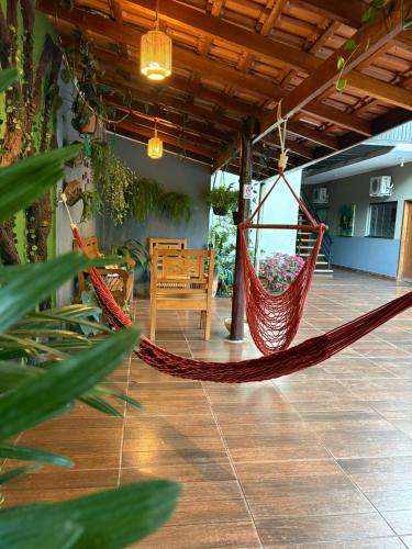 a patio with a hammock and a table and chairs at POUSADA EIRU in Bonito