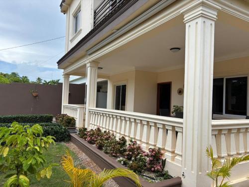 a white house with columns and flowers at Casa Canephora in Las Galeras