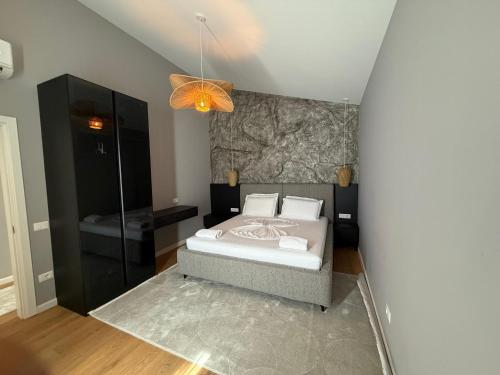 a bedroom with a bed and a chandelier at Bujtina Ajazi in Golem