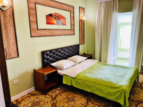 Un dormitorio con una cama con un edredón verde. en Aeroport Rooms, en Chişinău