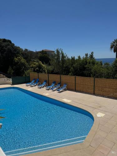 une piscine avec des chaises longues et l'océan dans l'établissement Quiet sea view with pool, à Cannes