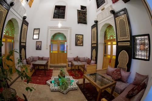 a living room with tables and couches in a building at Riad Shauala Fez in Fès