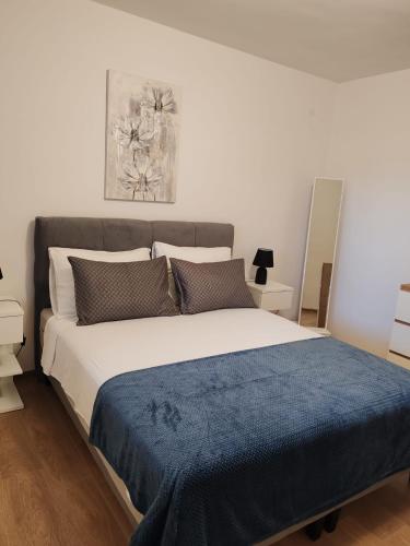 a bedroom with a large bed with a blue blanket at Apartman Nina in Kali