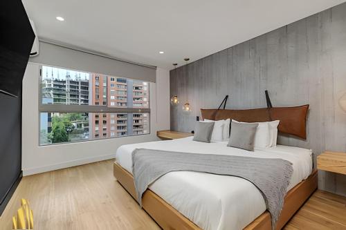 een slaapkamer met een groot bed en een groot raam bij Life 801 - Exclusive & Bright Apt/pool/gym/balcony in El Poblado