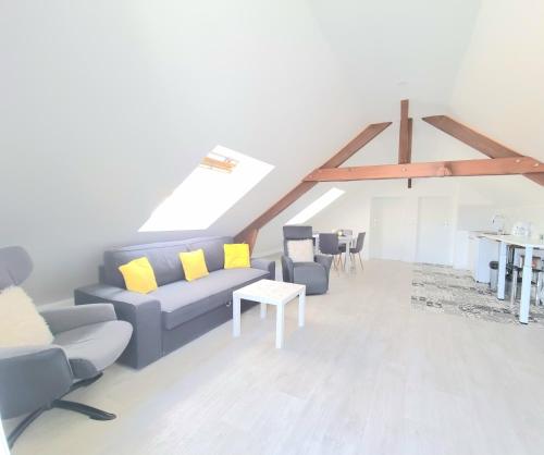 - un salon avec un canapé bleu et des oreillers jaunes dans l'établissement Appartement, proche Gare et Centre-Ville, à Blois