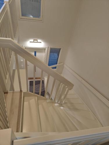 a white staircase in a house with a window at Nice 74,5 m2 app wih 4 beds and sauna in Espoo