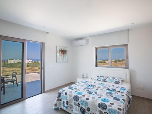 ein Schlafzimmer mit Bett und Blick auf das Meer in der Unterkunft Villa Ioanni Chrysos - Luxury And New 6 Bedroom Protaras Villa in Protaras